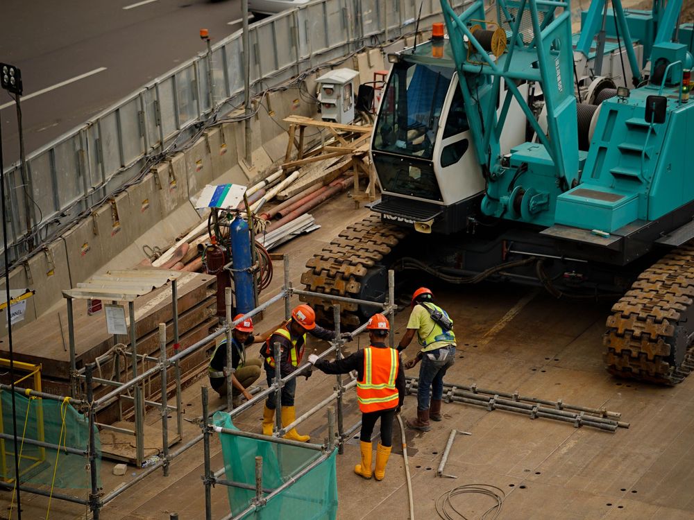 Kran und Arbeiter auf einer Baustelle im Wohngebiet